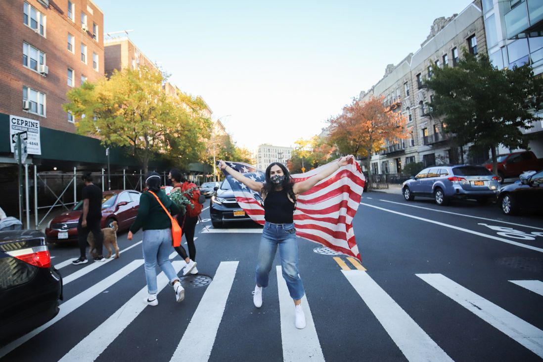 Woman holding American flag in street